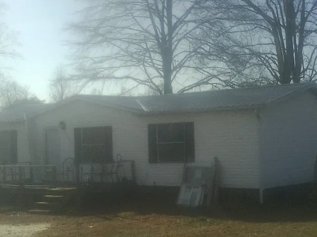 New metal roof on a white painted brick home on a foggy morning in Dixon